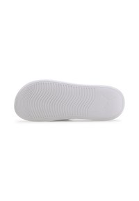 Semelle de sneaker blanche en caoutchouc texturé, dotée de motifs en vague pour une meilleure adhérence et d'un logo imprimé. Design plat, bords lisses, détail minimal.