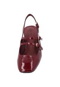 Röd lackskinnsko med rund tå, två justerbara remmar och slingback-design. Slät, glänsande yta; subtil märkning inuti.