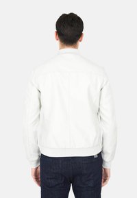 Giacca bomber in pelle bianca con polsini e orlo a costine. Texture liscia, design minimalista, con retro semplice senza decorazioni.