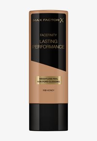 Fond de teint Max Factor Facefinity en 110 Honey. Tube beige impeccable avec des accents noirs et dorés, arborant une étiquette de formule non obstruante.
