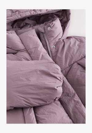 Veste matelassée de couleur violet clair, confectionnée en tissu doux et froissé. Dispose d'une fermeture éclair et de boutons-pression. Manches épaisses et texturées.