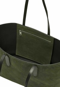 Zielona torba tote z zamszu z skórzanymi akcentami, wewnętrzną kieszenią na zamek błyskawiczny i wytłoczonym wzorem logo. Duży, otwarty design z podwójnymi ramiączkami.