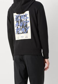 Felpa nera con cappuccio caratterizzata da una grande stampa grafica sul retro con testo blu e bianco, polsini e orlo a costine.