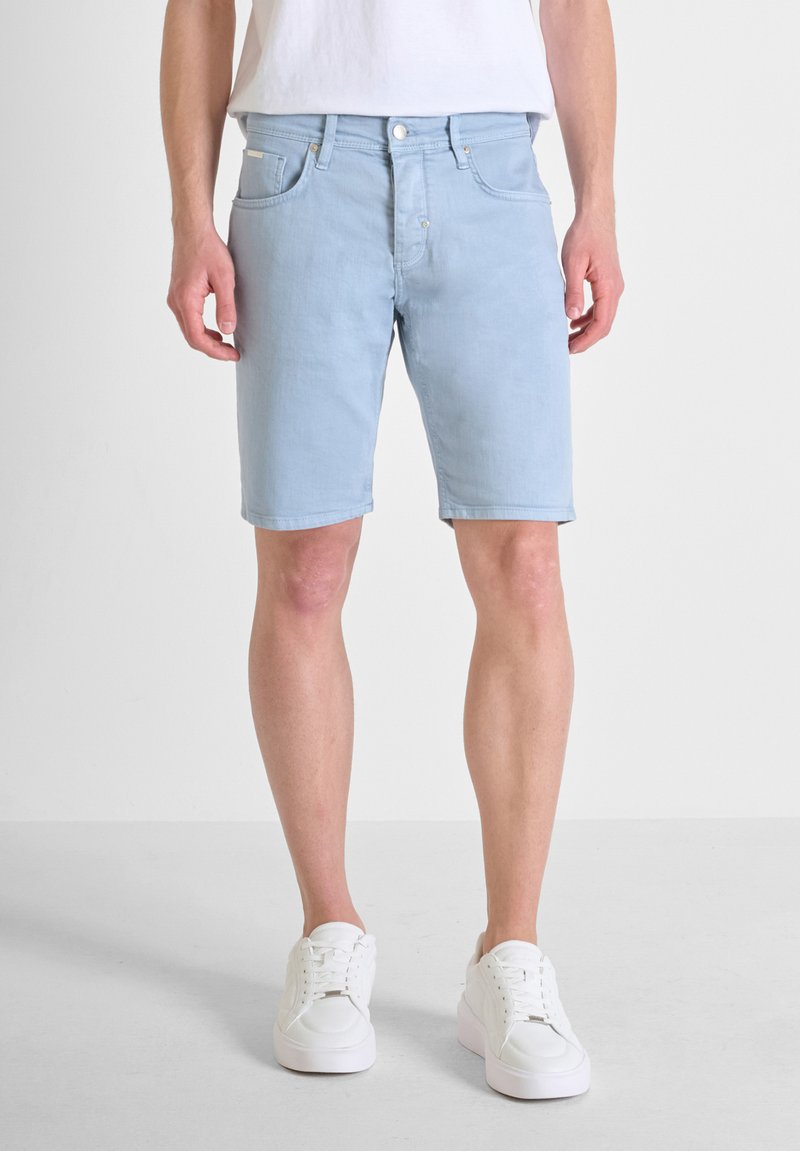 Shorts de mezclilla azul claro con un corte clásico, que cuentan con cinco bolsillos, un pasador para cinturón y una textura lisa, ligeramente deslavada.
