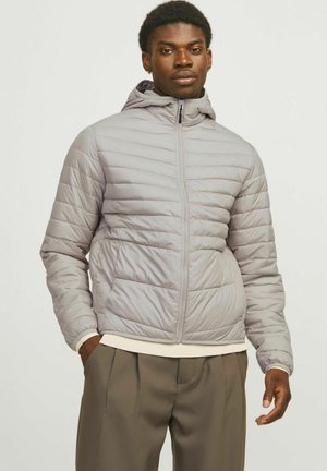 Gray puffer jacket with a zip closure, quilted texture, and attached hood. Features side pockets and elastic cuffs, worn over a white sweater.