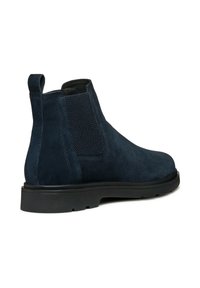Botas Chelsea de ante marino con paneles laterales elásticos, una lengüeta y una suela de goma negra resistente. Textura suave y diseño elegante.