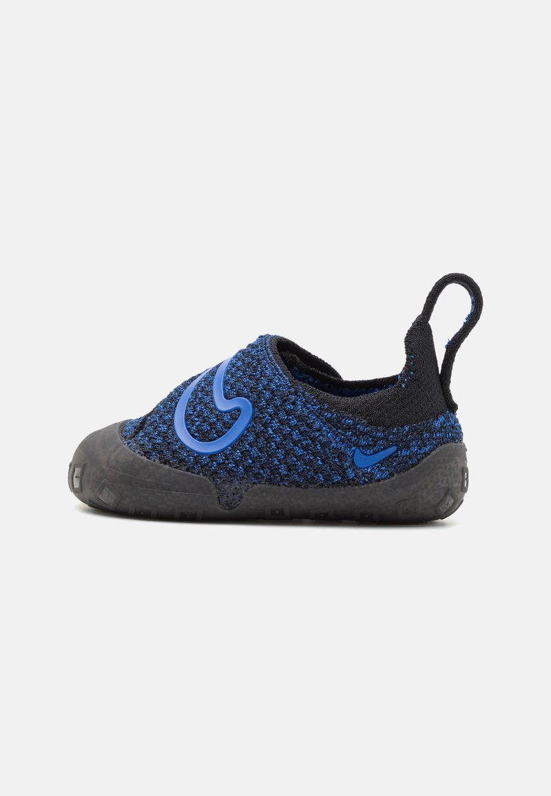 Ballerines tricotées bleues à enfiler avec des accents noirs, bout rond, semelle en caoutchouc texturée et un détail de logo bleu sur le côté.