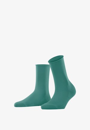 Grüne, knöchellange Socken aus einem glatten, dehnbaren Material mit einem gerippten Bund und einer nahtlosen Spitze für Komfort und Passform.