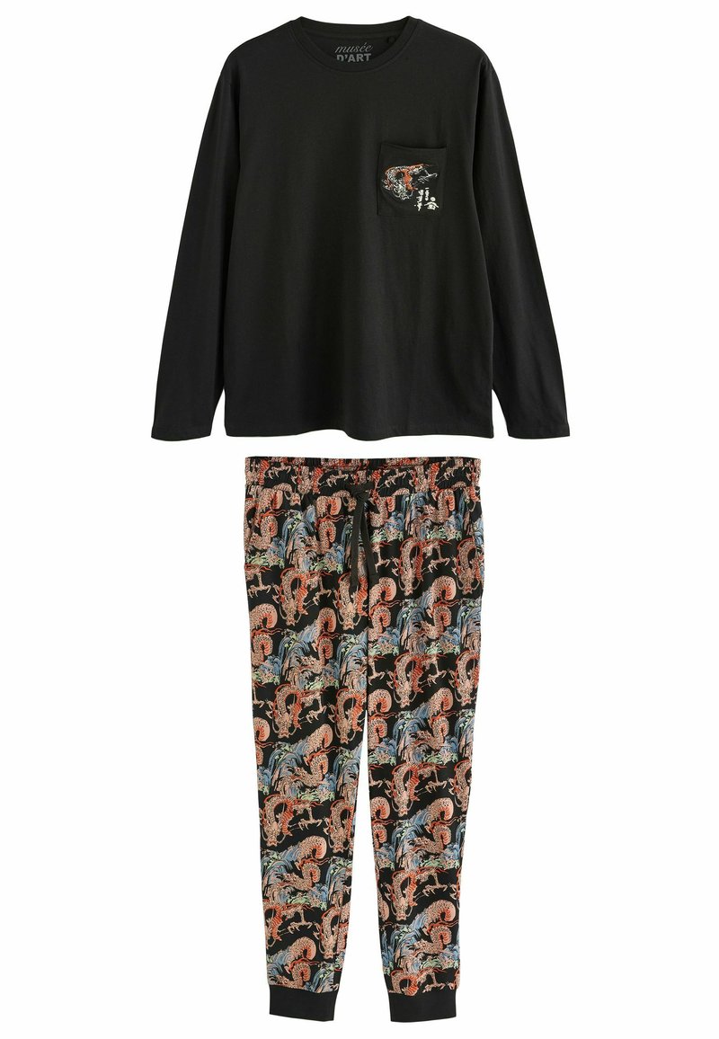 Schwarzes Langarmoberteil mit einer Tasche und grafischem Design, kombiniert mit gemusterten Pyjamahosen in Rot-, Blau- und Schwarztönen.