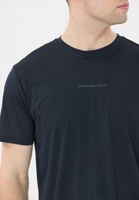 Marineblå atletisk t-shirt lavet af letvægtsstof, med rund halsudskæring og et diskret "ENDURANCE" logo på forsiden.