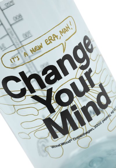 Prozoren stekleni zvočnik za vodo temno črnim tiskom prikazuje napis "Spremeni svoje misli", obdan z zlatim govornim mehurčkom z napisom "To je nova doba, človek!"