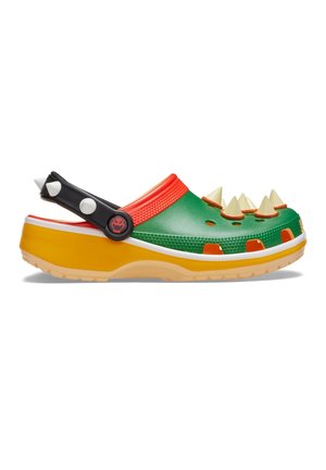 Sabot vert, orange et jaune avec une sangle noire ornée de pointes blanches et crème sur le dessus à des fins décoratives.