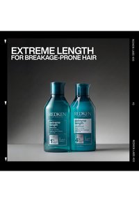 Zwei türkisfarbene Flaschen Redken Extreme Length Shampoo und Conditioner für bruchanfälliges Haar auf neutralem Hintergrund mit Produktbeschreibungstext.