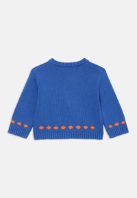 Sweater azul com mangas longas, decote e punhos canelados, apresentando um padrão de losangos laranja ao longo da bainha inferior. Textura de malha suave.