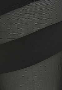 Gros plan sur un tissu avec des sections gris foncé et noir tissées serrées formant un motif abstrait courbé.