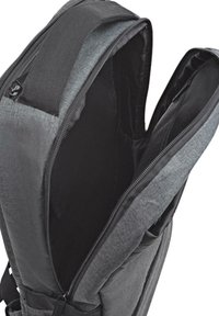 Mochila gris con un exterior de tela texturizada, compartimentos dobles con cremallera y un interior forrado con material negro. Se pueden ver las correas ajustables.