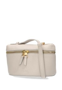 Sac à main en cuir crème avec une finition texturée, matériel de fermeture éclair doré, tirettes de fermeture éclair doubles et une courte poignée de portage.