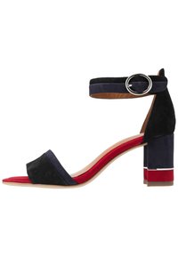 Czarne i granatowe zamszowe sandały na obcasie z paskiem wokół kostki, kwadratowym noskiem oraz słupkowym obcasem z czerwonymi i granatowymi akcentami.