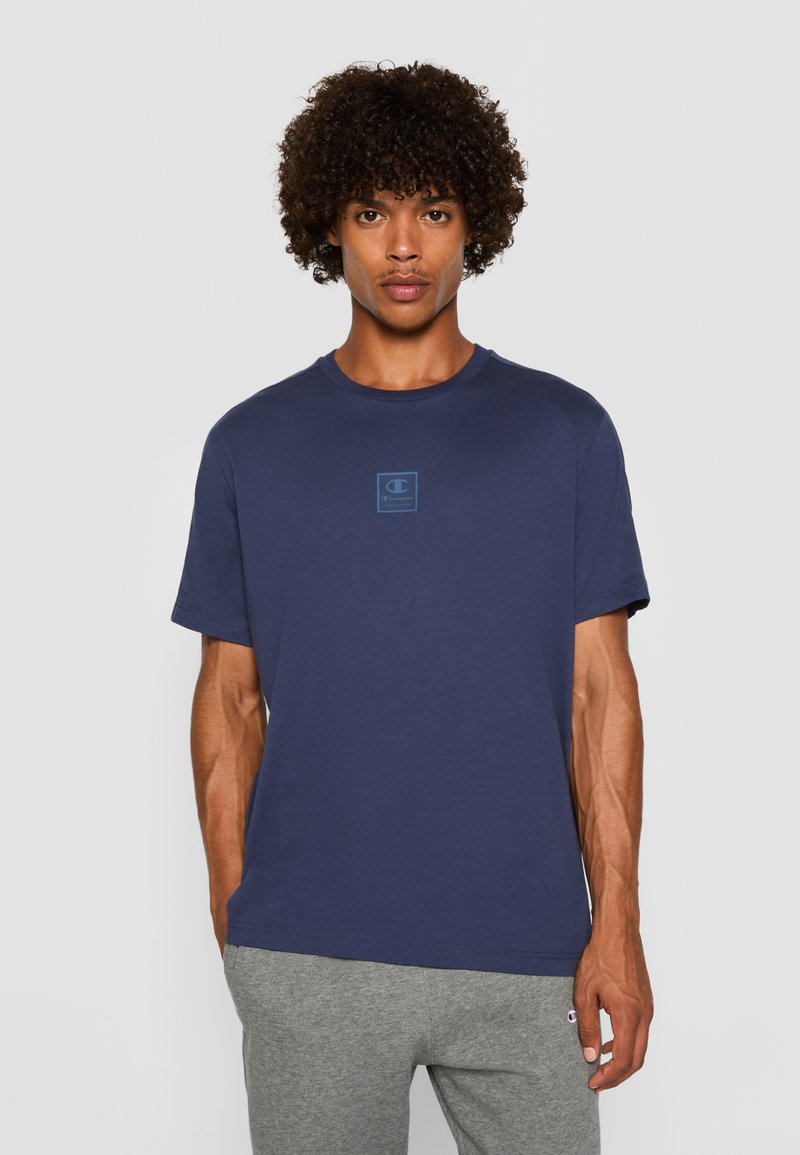 Marineblå t-shirt med korte ærmer, der har et lille blåt logo på brystet. Lavet af blødt stof, med rund halsudskæring og normal pasform.