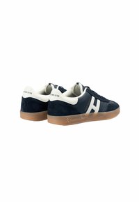 Zapatillas de ante azul marino con un logo y acentos blancos, que cuentan con una suela de goma y elementos de diseño distintivos en el talón y el lateral.