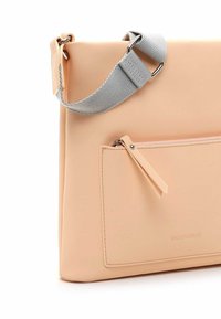 Růžová koženková taška s šedým nastavitelným popruhem, obdélníkový design, přední kapsa na zip a embosované jméno značky. Hladký povrch.
