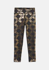 Leggings negros con un patrón de diamantes metálicos dorados y logotipos repetidos. Textura suave con un diseño ajustado y una cintura de altura media.