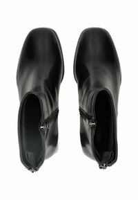Botas de tobillo de cuero negro con textura suave, punta cuadrada y cremalleras laterales. Presentan un tacón bajo y un forro interior suave.