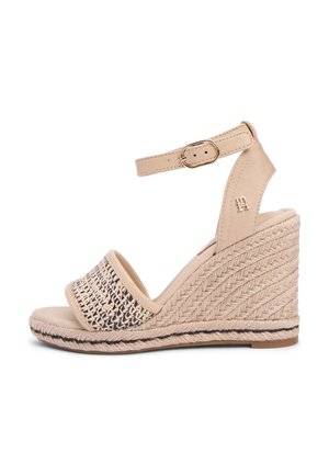 Beiger Keilsandalette mit geflochtenem vorderem Riemen, Knöchelriemen mit Schnalle und geflochtenen Seil-Details am Absatz.