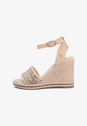 Beige kilehæl sandal med flettet forreste rem, ankelrem med spænde og detaljer af fletet reb på hælen.