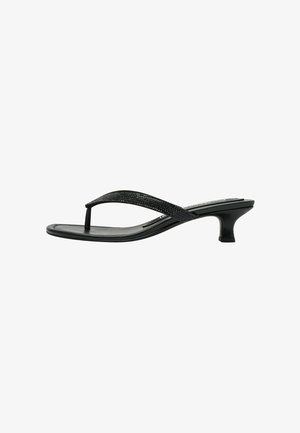 Sandale noire à tongs avec une sangle texturée, design minimaliste et petit talon incurvé. Semelle lisse sans motifs ni accents visibles.
