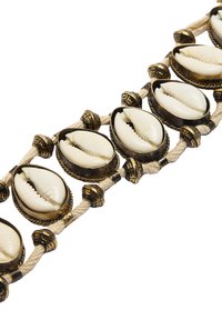 Pleciona bransoletka z mosiężnymi akcentami muszelek cowrie oraz ozdobnymi plecionymi detalami, z neutralną bazą z liny i teksturowymi metalowymi zdobieniami.