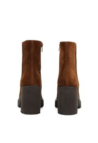 Stivaletti in suede marrone con tacco a blocco, dotati di una cerniera sul retro. Il design è elegante con una texture liscia e una silhouette aderente.