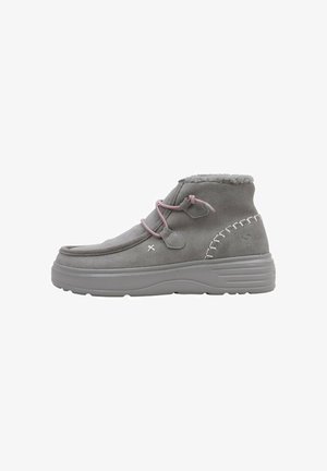 Bottines en suède gris avec des lacets roses, doublure en fausse fourrure et semelle en caoutchouc texturé. Présente des coutures décoratives sur les côtés.