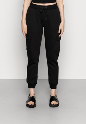 Zwarte sweatpants met elastische boorden, tailleband met trekkoord en zij cargo pockets. Draag het met zwarte sandalen met banden.