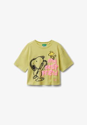 Camiseta corta de color verde claro con ilustración negra de Snoopy y Woodstock amarilla, y texto en rosa "mi mejor amigo" en el frente.