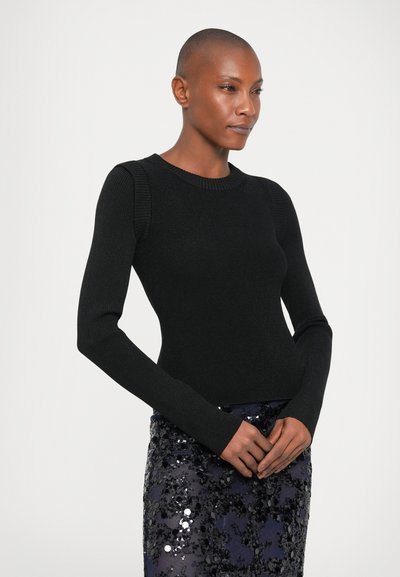 Sweater preto canelado com mangas longas e decote redondo, combinado com uma saia azul marinho com lantejoulas. Textura suave, design ajustado.