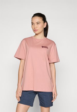 Rosa bomullströja med korta ärmar och rundad halsringning, med en mörk logotyp på vänster bröstområde. Kombinerad med marinblå shorts.