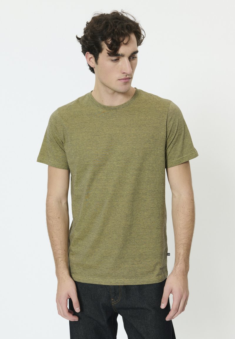 T-shirt vert olive en tissu doux et texturé avec manches courtes et col rond. Présente des rayures horizontales discrètes.