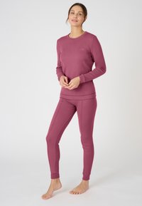 Completo in due pezzi composto da una maglia a maniche lunghe e pantaloni aderenti di un solido colore rosa scuro, realizzato in un morbido tessuto testurizzato.