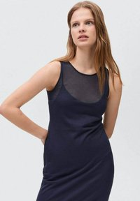 Abito senza maniche blu navy con scollo trasparente, forma aderente e texture liscia. Tessuto morbido, design minimale senza motivi o embellishments.