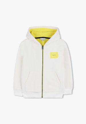 Sweat à capuche blanc zippé avec une capuche doublée de jaune, des poches frontales et un petit patch logo jaune sur le côté gauche. Texture de tissu doux.