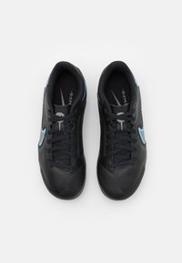 Botas de fútbol negras con parte superior de cuero texturizado, que presentan acentos azules y lados perforados. Diseño con cordones para un ajuste seguro.