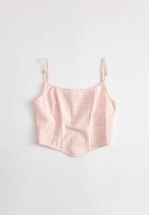 Camisole courte à carreaux vichy rose et blanc avec fines bretelles réglables et petits détails en forme d’étoile sur chaque bretelle.