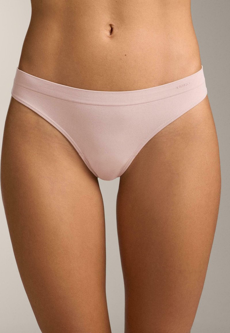 Svetlo roza bombažne bikini hlačke s mehkim, širokim pasom in gladko teksturo, z organskimi linijami in minimalnimi šivi.