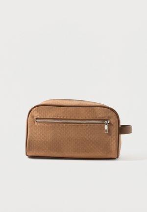 Bolsa de aseo texturizada de color marrón claro con un bolsillo frontal horizontal con cremallera y asa lateral, sobre un fondo blanco liso.