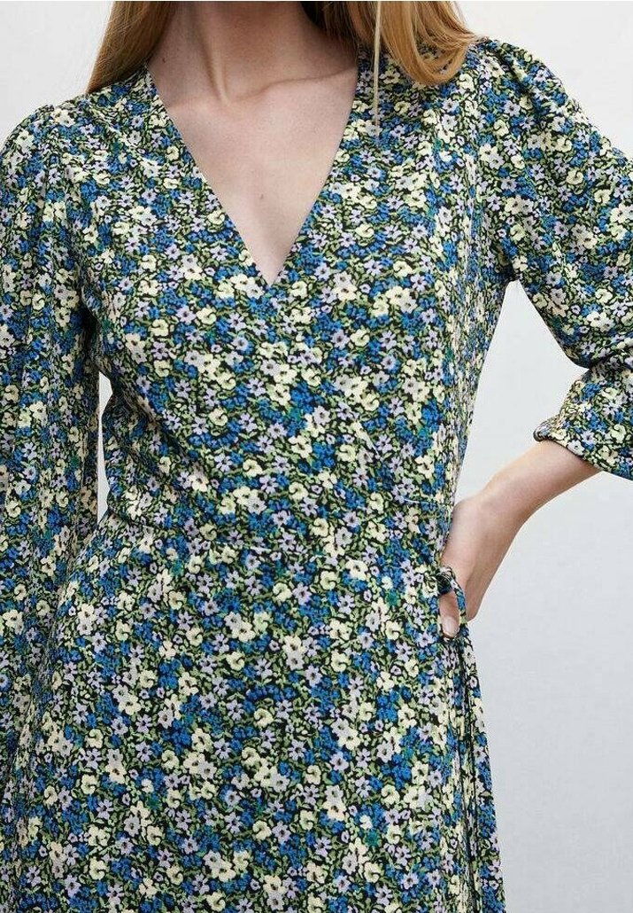 Blumenkleid mit tiefem V-Ausschnitt, dreiviertelÄrmeln und einer Mischung aus blauen, grünen und weißen Blumen auf dunklem Hintergrund.