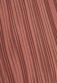 Tejido plisado en un suave color rosa, con pliegues verticales. La textura parece suave con un brillo sutil, creando una apariencia uniforme.