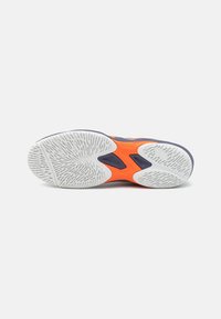 Semelle de chaussure de sport avec une bande en caoutchouc blanc dotée de rainures texturées, des accents de semelle intermédiaire orange vif et une base lisse noire.