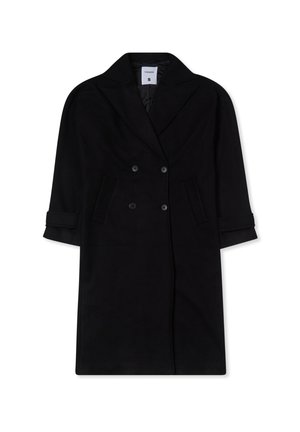 Cappotto nero doppiopetto realizzato in tessuto morbido, con ampie rever, due tasche frontali e maniche arrotolate. Taglia S.