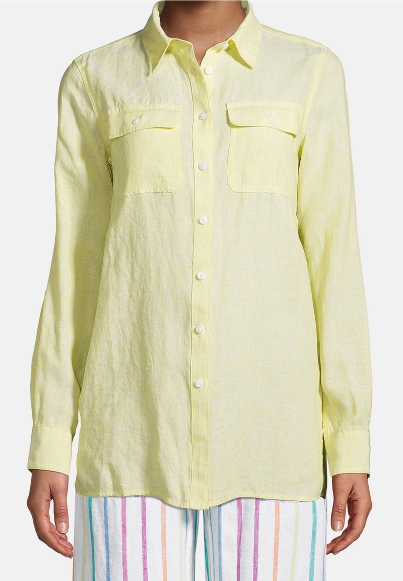 Camicia a maniche lunghe gialla chiara con bottoni, realizzata in un tessuto testurizzato; presenta due tasche sul petto e bottoni bianchi.